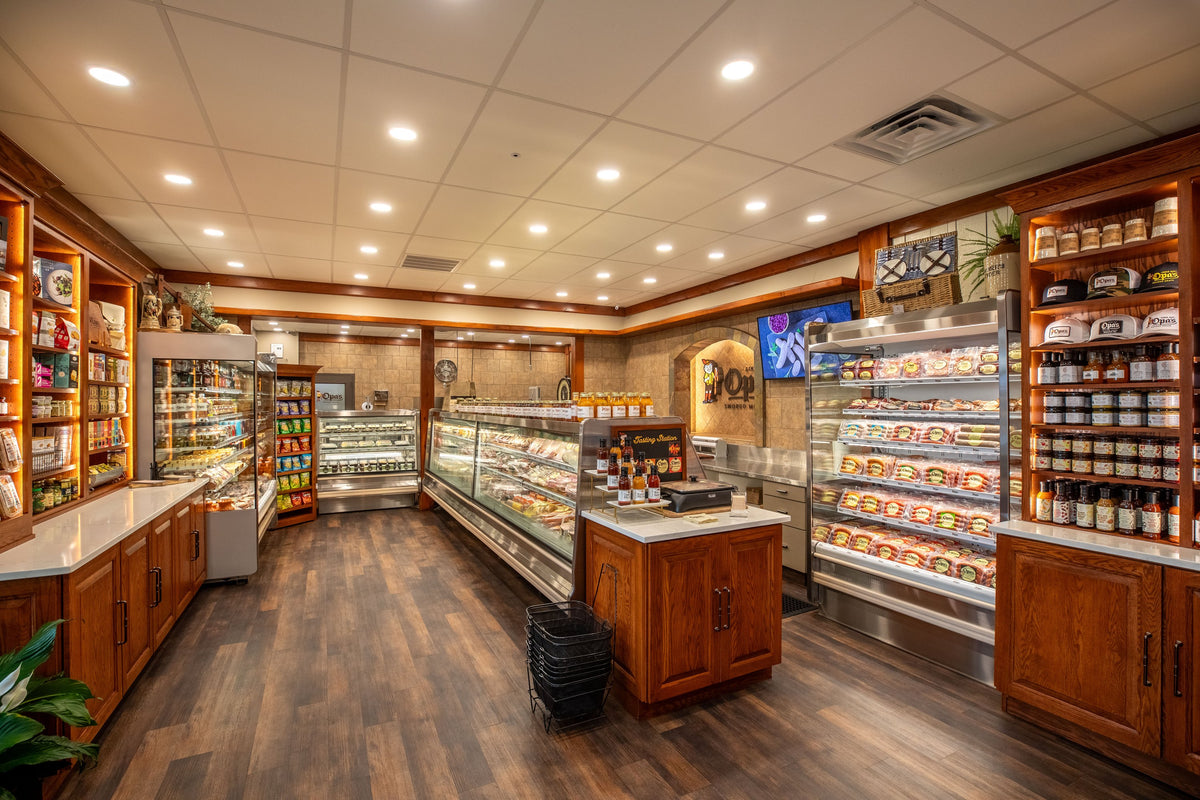 Inside Opa's Deli & Market in Fredericksburg: the deli case, the tasting station, smoked sausage in the cooler and the market shelves